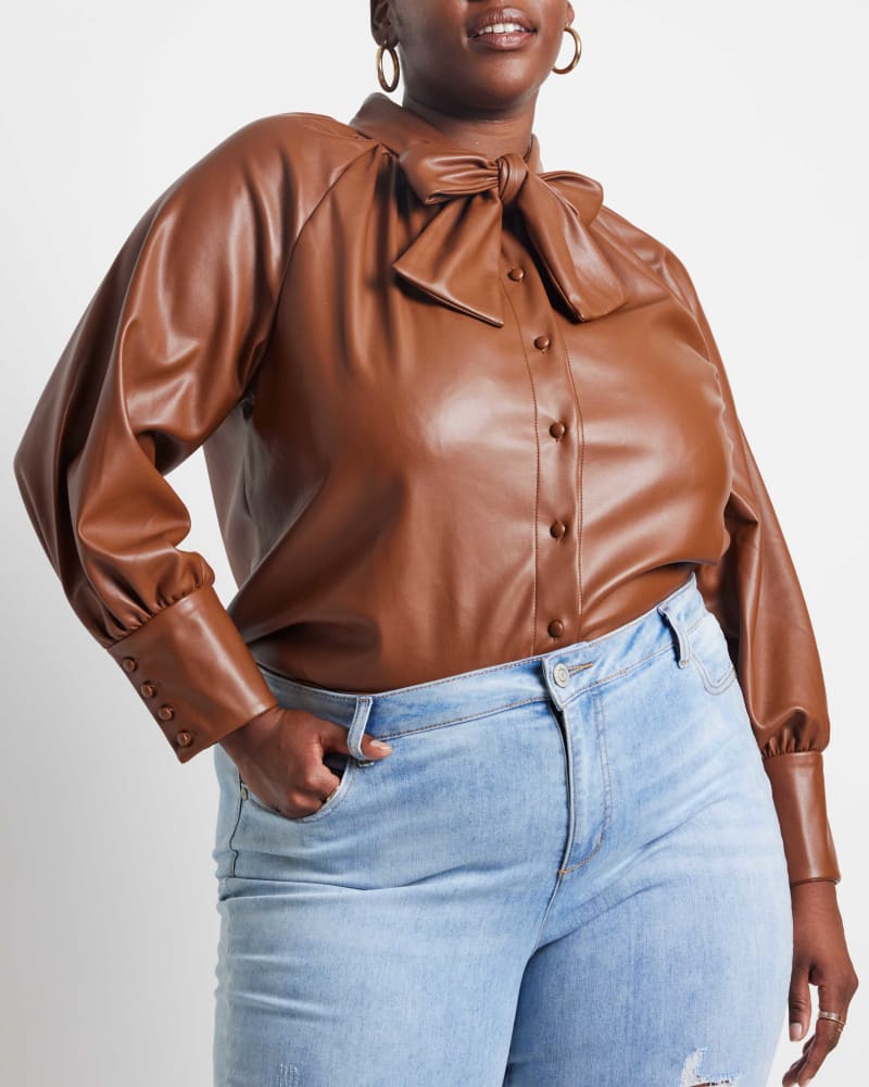 Front of a model wearing a size 14 Verity Faux Leather Tie Neck Top in Sorrel Horse by ELOQUII. | dia_product_style_image_id:236317